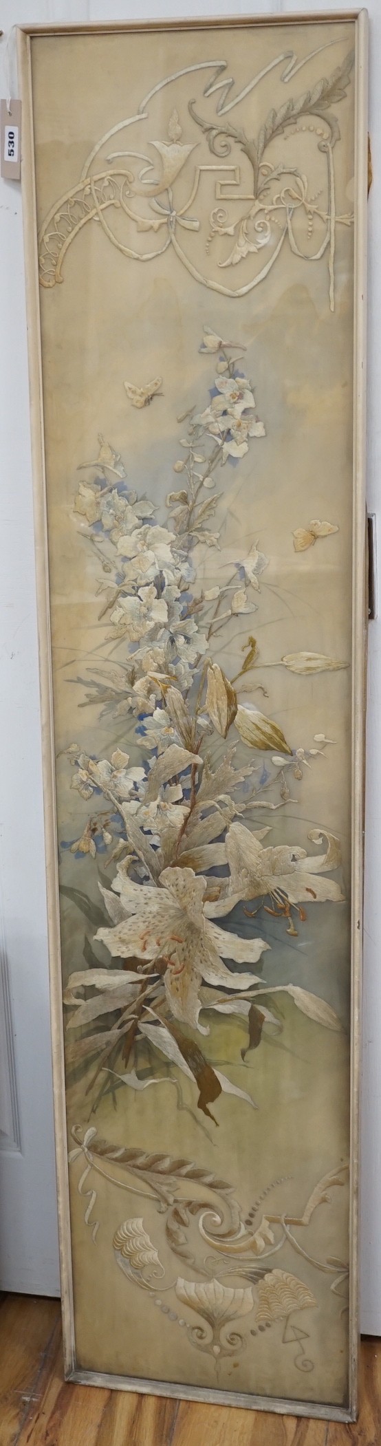 A framed silk embroidered panel, possibly French, cut from a larger piece, 137cms high x 27wide